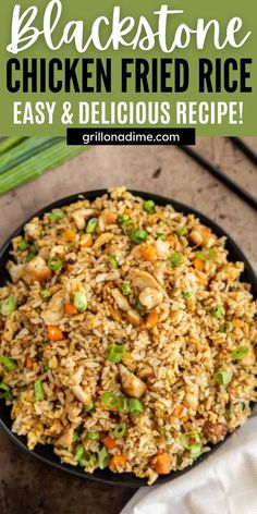 chicken fried rice in a black bowl with green onions and carrots on the side