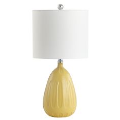 a yellow table lamp with a white shade on the base and a light bulb attached to it