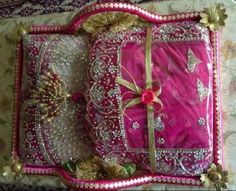 a pink and gold pillow sitting on top of a white bed covered in lots of beads