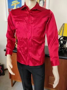 This red satin shirt was difficult to capture the closest match as to colour. It is not a raspberry as the first photo. Maybe fire engine red and so shiny too. It is marked a small 36/37cm. The condition is good Measurements are Shoulder to shoulder 39cm Chest 98cm Sleeves shoulder to cuff 59cm Length shoulder to hem 68cm Formal Red Long Sleeve Shirt, Red Long Sleeve Formal Shirt, Fitted Long Sleeve Satin Shirt, Fitted Red Shirt For Party, Red Collared Shirt For Party, Red Collared Party Shirt, Elegant Long Sleeve Red Shirt, Elegant Red Long Sleeve Shirt, Classic Red Tops For Party