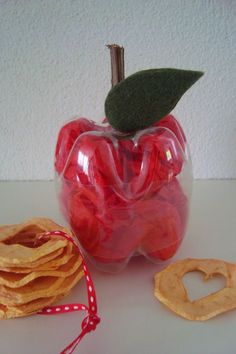 an apple with a leaf on top of it and some crackers next to it