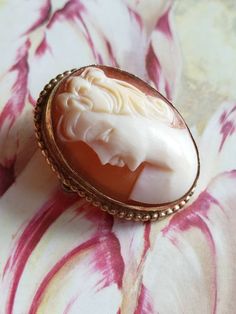 This is a vintage AMCO cameo brooch/pendant. It is oval and is stamped 1/20 14 K GF. The cameo measures just over .75 x a bit over 1 inch. Don't forget to stop in at my other Etsy shop... http://www.etsy.com/shop/xtdesigns. Follow me on Twitter at... MyYiayiaHadThat@MyYiayiaHadThat. If you have a wish list or are looking for something specific, please ask. I may have exactly what you are looking for. As always please convo me with any questions or concerns regarding this item or with any interna Vintage Oval Brooch With Cabochon, Vintage Oval Cabochon Brooch, Antique Oval Cameo Brooch, Antique Gold Oval Brooch, Gold Oval Cameo Brooch, Antique Gold Oval Brooches, Vintage Oval Brooches For Collectors, Vintage Oval Brooches For Wedding, Vintage Oval Wedding Brooches