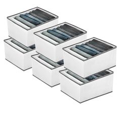 four white storage boxes filled with clothes