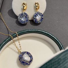 Immerse yourself in the celestial beauty of our Starry Dreams collection. This exquisite set features a Baroque pearl intricately set with stunning blue gemstones, symbolizing a perfect blend of art and nature. The set includes a pendant necklace, a ring, and earrings, each showcasing the unique allure of the Baroque pearl. The pendant measures 1.85*1.85 cm, elegantly suspended on a 52 cm necklace with an additional 5 cm extension for adjustable length. Elevate your style with this mesmerizing combination of artistic design and the timeless elegance of pearls. This thoughtful 3-piece pearl set features fine quality AAA freshwater baroque pearls that are blemish-free with a rich luster. This pendant and earring set is simple, elegant, and classic. Jewelry Set includes: Pendant Necklace A pa Elegant Jewelry With Round Pendant And Natural Stones, Elegant Sapphire Necklaces With Sparkling Stones, Elegant Sapphire Necklace With Sparkling Stones, Elegant Gold Jewelry Sets With Stones, Elegant Natural Stones Jewelry Gift For Her, Elegant Jewelry With Natural Stones As Gift For Her, Elegant Natural Stone Jewelry As A Gift For Her, Luxury Blue Pearl Pendant Necklace, Luxury Blue Pearl Pendant Necklaces