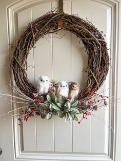 two little birds sitting on top of a wreath