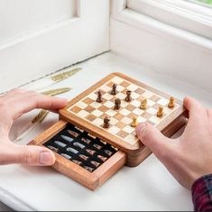 two hands playing chess on a wooden board