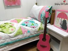 a pink guitar sitting on top of a wooden floor next to a white nightstand and bed