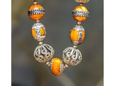 Ethnic-style 25-inch necklace made of Nepalese Copal Amber Resin and silver beads, Moroccan Filigree Silver beads, and antique Mother-of-Pearl over silver Tibetan beads. The largest silver filigree bead is 30x27 mm. The smallest mother-of-pearl beads are 8mm. Strung on a fine copper chain. Copal Amber is tree resin (not tree sap!) that is very old (expert opinions range from 1000 to 100,000 years old) but has not yet gone through the fossilization process that makes real amber (such as Baltic Am Silver Beaded Bohemian Pearl Necklace, Silver Bohemian Pearl Necklace With Beads, Bohemian Silver Beaded Pearl Necklace, Silver Beaded Temple Necklace For Festivals, Festival Silver Beaded Temple Necklace, Festive Silver Beaded Pearl Necklace, Silver Pearl Necklace With Large Beads For Gift, Artisan Silver Beads Jewelry For Festivals, Artisan Silver Bead Jewelry For Festivals