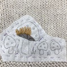 a piece of cloth with an animal design on it and a needle in the middle