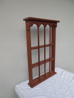 a wooden shelf sitting on top of a white bed