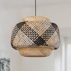 a woven light fixture hanging from a ceiling