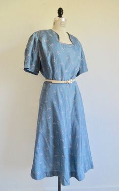 "This 1940's to early 50's dress has a pretty Spring taffeta print of pink and white dots on a dusty blue background. Rare larger size. Bodice has sweetheart style neckline with small fabric tabs at the bottom opening for decoration. Princess line darts for shape and a pleat at the front shoulder edge as well as short sleeves. Set in waist. Mid calf gored flared skirt. Unlined. Side zipper closure. **I am including the contemporary ivory leather belt with purchase. Label: A Lady Petite Condition Princess Line, Taffeta Dress, 50s Dresses, Flared Skirt, 50's Dress, Long Maxi Dress, Velvet Dress, Fit And Flare Dress, Dusty Blue