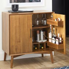 a wooden cabinet with wine glasses and liquor bottles