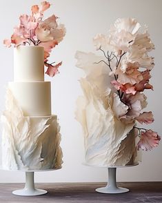 there are two cakes with flowers on the top one is white and the other is pink