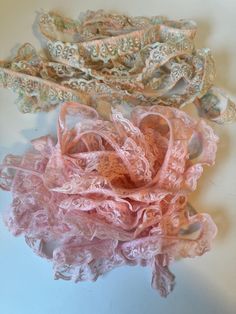 three pieces of pink and green lace on a white surface