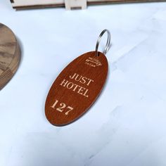 a wooden keychain with the name just hotel engraved on it