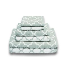 four towels stacked on top of each other in front of a white background with an ornate pattern