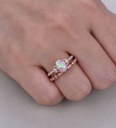 a woman's hand with an opal and diamond ring