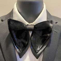 The item is a handmade black velvet and satin jumbo butterfly bow tie.  The bow tie is large in size with a velvet top framed with bridal satin on bottom and an adjustable neck strap.  The bow tie's dimensions are 6 inches wide and 5 inches high.  The item would be a perfect accessory to enhance a wardrobe for a special or formal occasion. Party Bow Tie With Black Ribbon, Party Bow With Black Ribbon In Standard Tie, Party Standard Tie Bow With Black Ribbon, Party Bow With Black Ribbon, Tuxedo Bow Tie For Party, Tuxedo Bow For Party With Ties, Butterfly Knot Bow For Black-tie Events, Black Ribbon Fitted Bow Tie For Party, Adjustable Black Bow Tie For Party