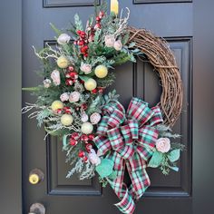 a wreath with flowers and greenery is hanging on the front door to give it a festive feel