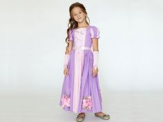 Step into a storybook fantasy with our enchanting Rapunzel girls dress. Crafted with the utmost attention to detail, this purple fairytale princess dress is perfect for any little girl's fantasy-themed occasions. Whether celebrating a birthday as the long-haired princess, attending a ball, or choosing the ideal Halloween costume, our junior Tangled dress crafted from soft cotton and adorned with satin ribbon ensures elegance and comfort. The legend of Princess Rapunzel, a beautiful maiden trappe Snow White Princess Dress For Cosplay Events, Princess Style Dress For Cosplay Events, Fairytale Dress With Fitted Bodice For Cosplay, Fairycore Dresses For Cosplay And Costume Parties, Snow White Princess Dress Costume, Fairytale Halloween Dress, Purple Fantasy Costume Party Dress, Purple Fantasy Dress For Costume Party, Fantasy Style Purple Dress For Costume Party