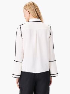 This stunning and unique blouse is a bold choice for fashion lovers who like to stand out. The black trim along the seams creates a striking contrast with the off-white fabric. The pearl buttons add a touch of elegance, while the flounce sleeves have slits at the end for extra flair. The blouse has a classic shirt collar and a hip-length hem. Final Sale- No returns or exchanges. Color- Classic cream and black. Regular fit. Shirt collar. Long sleeve. Flounce sleeve. Button front. Sits at hip. Mis Elevated Fashion, Statement Blouse, Jumpsuit And Blazer, Unique Blouse, Short Sleeve Cardigan, Curvy Dress, Flounce Sleeve, Pearl Buttons, Black Trim