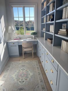 a room that has a rug on the floor in front of some bookshelves