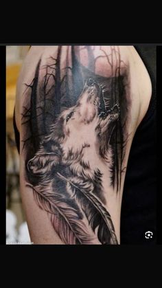 a man with a wolf tattoo on his arm holding a feather and looking up at the sky