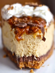 a piece of cheesecake on a plate with whipped cream and caramel toppings