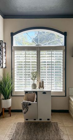 a living room filled with furniture and a window covered in shuttered glass shades on the windowsill