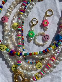 several necklaces are arranged together on a white surface with beads and charms around them