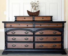 an old dresser is painted black and brown