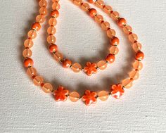 This orange necklace, beaded with ceramic  flower beads, for women is cotton cord based, that makes it durable, strong for everyday wear, ideal for the Summer time holiday. This ceramic necklace will look great with bright Summer outfit away and on the beach. Also as good with darker wearings in Autumn, Winter or Spring, layering together with other necklaces during other time of the year. To assemble this necklace were used orange colour beads. The orange clear 6-8mm mixed with ceramic flower s Bright Summer Outfits, Spring Layering, Necklace Ceramic, Fleur Orange, Orange Necklace, Ceramic Necklace, Small Gift Boxes, Women Necklace, Trendy Necklaces