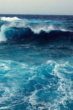 the ocean is full of blue water and waves that are crashing on top of each other