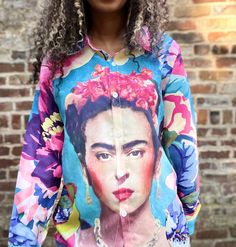 Our Frida in the Garden Button-up Blouse is perfect for channeling your inner Frida Kahlo in style! Light and breezy, this unique top features an artwork of the iconic artist, surrounded by a lively garden of birds - the perfect look for any day you want to feel like spring! Get ready to rock this beautiful blouse and make a bold statement! Product Details Material: Polyester fiberFit: Loose fit (like a shacket) *size small in the photosCare: Machine wash cold, hang to dryShipping: Imported (est Spring Multicolor Tops With Unique Print, Spring Bohemian Blouse With Graphic Print, Artistic Floral Print Tops For Spring, Multicolor Tops With Unique Print For Spring, Spring Artistic Multicolor Print Tops, Artistic Printed Tops, Artistic Multicolor Print Tops For Spring, Artistic Multicolor Floral Print Tops, Spring Beach Blouse With Graphic Print