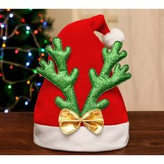 a red santa hat with green antlers and a gold bow