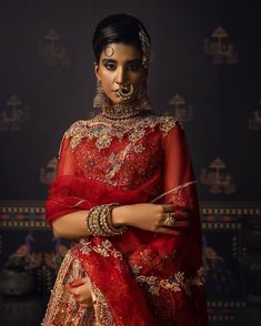 Indian Red Bridal Lehenga with Choli and Dupatta Dress is an epitome of tradition and royalty that gives the gorgeous bride a magnificent royal look at the wedding. Kora dabka, stonework, and Kundan details give a charming touch to this beautiful Lehenga Choli. Bridal Choli The sleeveless choli is gracefully emblazoned with luxury designs and dabka work. Kundan, floral designs, and shimmering adornments enhance the charm of the choli. Goldwork and a stylish back give a chic look to this bridal c Festive Gown With Dupatta For Traditional Ceremonies, Red Gown For Eid And Traditional Ceremonies, Red Anarkali Gown For Traditional Ceremonies, Ceremonial Bollywood Style Red Lehenga, Red Ceremonial Lehenga For Festive Occasions, Traditional Gown With Sheer Dupatta For Festivals, Ceremonial Red Lehenga With Dupatta, Tilla Dupatta For Reception And Festivals, Festive Kundan Gown For Traditional Ceremonies