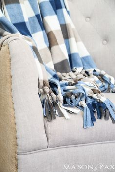 a blue and white checkered blanket sitting on top of a couch