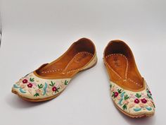 Ethnic Indian/Pakistani style shoes durable and hand stitched with genuine leather sole and leather padded cushion inside. These lovely pair of khussa have a base white raw silk fabric dotted with multi colored thread work in flower design. They offer comfort and style, while still looking fabulous in these. Perfect or brides or everyday outfits. We offer many different designs of shoes to choose from. See our page for more of our collection! We ship out in a timely matter, wrapped in care for a Traditional Round Toe Flats With Dori Work, Traditional Flats With Dori Work And Round Toe, Traditional Dori Work Flats With Round Toe, Traditional Meenakari Slip-on Flats, Traditional Embroidered Flats With Flat Heel, Traditional Embroidered Round Toe Flats, Bohemian Embroidered Flats For Festivals, Dori Work Flats For Festival, Closed Toe Flats With Handwork For Summer