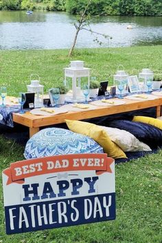 a father's day party with blue and yellow decorations on the grass near water