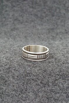 This sterling silver ring was made by Navajo silversmith Bruce Morgan. The inside is signed B Morgan and stamped sterling.Size: 7.5Length: 1/4"Free shipping on all orders! We ship with USPS and always include tracking. All orders ship within a day of payment.Returns are accepted up to 30 days after you receive your order. Just send us a message. Our shop offers cash back or store credit. The item must be returned in new condition. Artisan Sterling Silver Wide Band Ring, Artisan Sterling Silver Ring With Etched Details, Artisan Sterling Silver Etched Rings, Artisan Engraved Sterling Silver Ring 925, Silver Southwestern Style Rings, Southwestern Style Untreated Silver Rings, Stamped Sterling Silver Wide Band Jewelry, Southwestern Engraved Rings For Anniversary, Southwestern Sterling Silver Rings For Anniversary