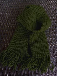 a green scarf laying on top of a metal table