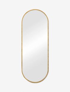 a gold framed mirror on a white wall, with the reflection of an oval frame