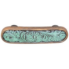 an ornate wooden handle with green paint on it