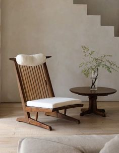 a wooden chair sitting next to a table on top of a hard wood floored floor