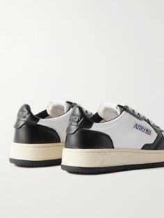 Autry revives the iconic 'Medalist' sneakers from the '80s for its new collection. Staying true to the original design, this two-tone leather version has signature logo appliqués, perforated toe boxes and vintage-inspired rubber soles. Low-top Leather Sneakers With Logo Patch, Retro Leather Custom Sneakers For Streetwear, Sporty Leather Sneakers With Logo Patch, Classic Low-top Sneakers With Logo Patch, Vintage White Leather Custom Sneakers, Retro Black Leather Sneakers, Retro Sneakers With Contrasting Heel Counter, Classic Leather Sneakers With Logo, Leather Low-top Sneakers With Logo Patch