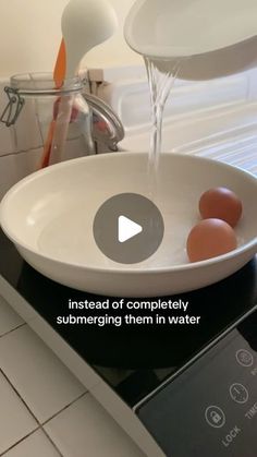 an image of eggs being washed in a bowl on the stove top with water coming out