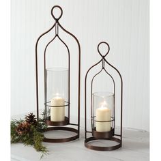 two candle holders with candles in them on a table