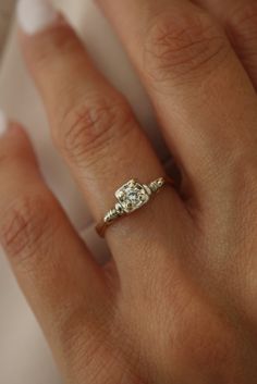 a woman's hand with a diamond ring on it