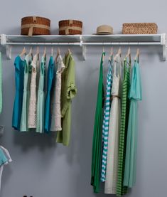 a closet with clothes and baskets hanging on the wall